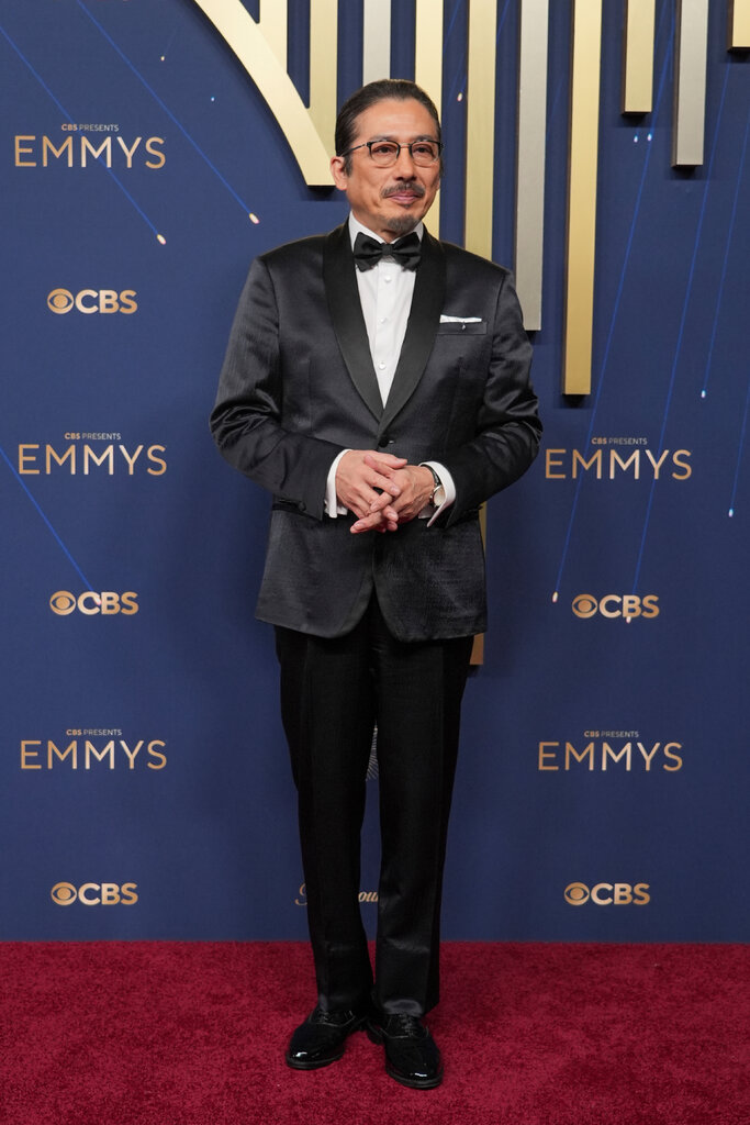 A man wears a black suit.