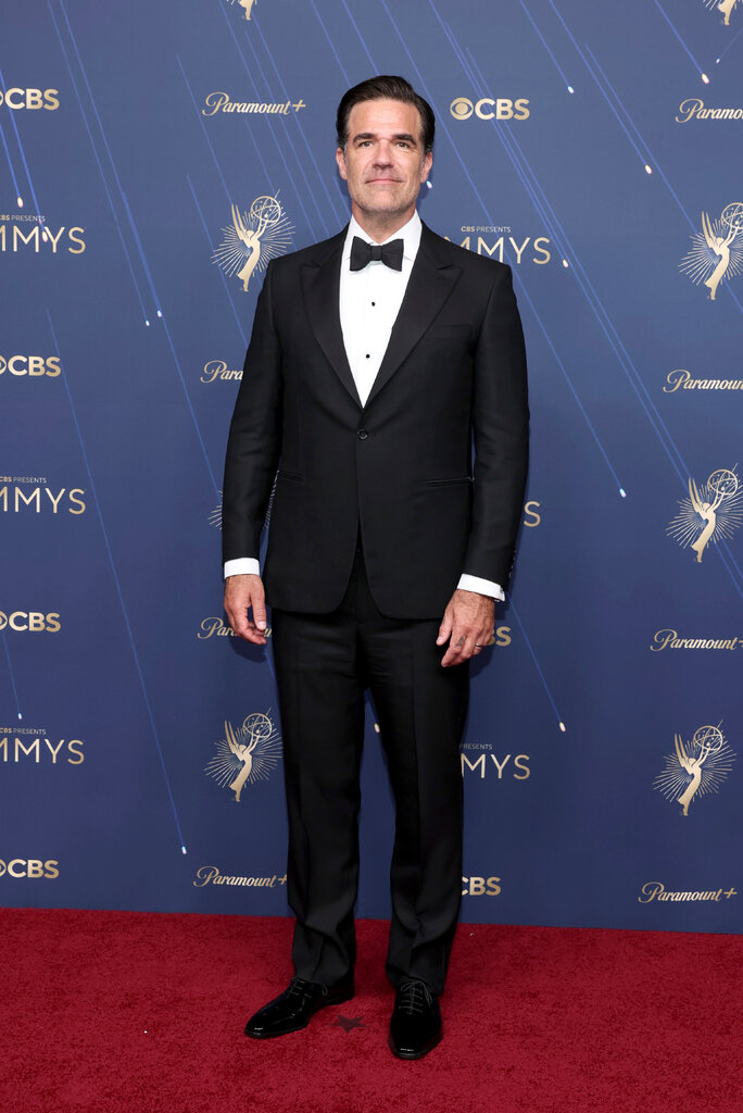 A man wears a black suit.