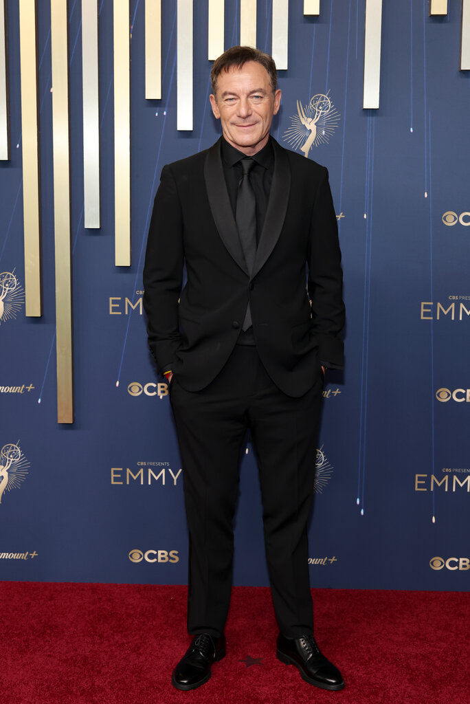 A man wears a black suit.