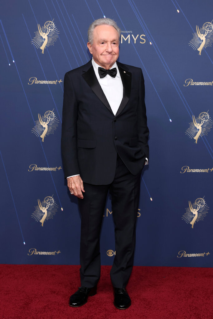 A man wears a black tuxedo.