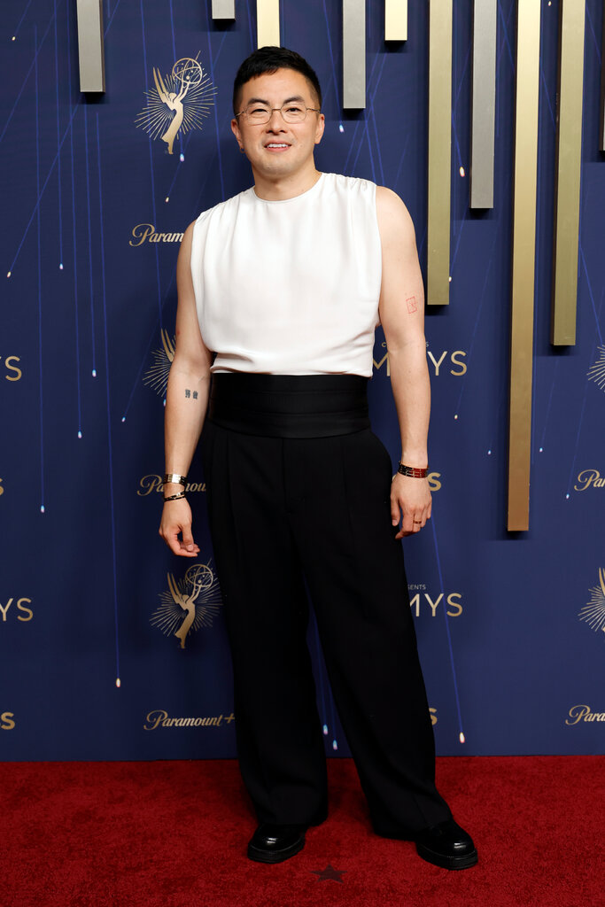 A mean wears a white sleeveless T-shirt with black pants.