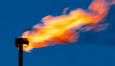 A blackened pipe with a large gout of flame swirling out of the top.