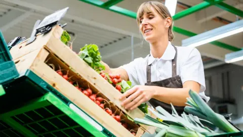 Getty Images Woman sorting vegetables in a supermarket or shop
