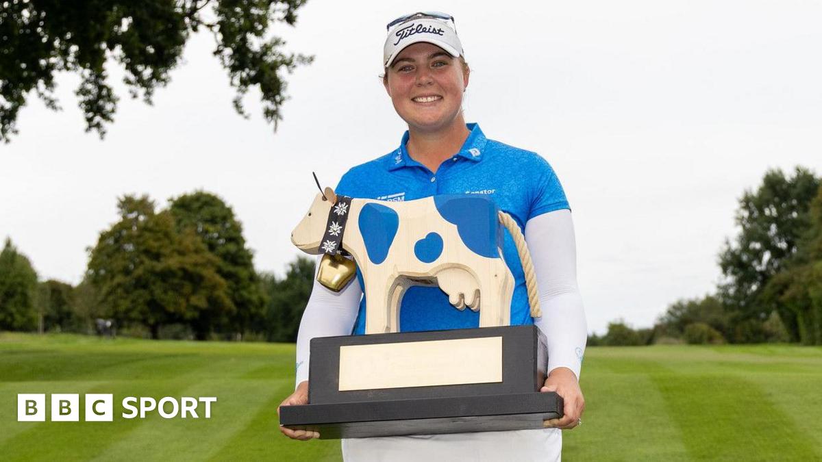 English golfer Alice Hewson smiles as she holds up the Swiss Ladies Open, which is in the shape of a cow