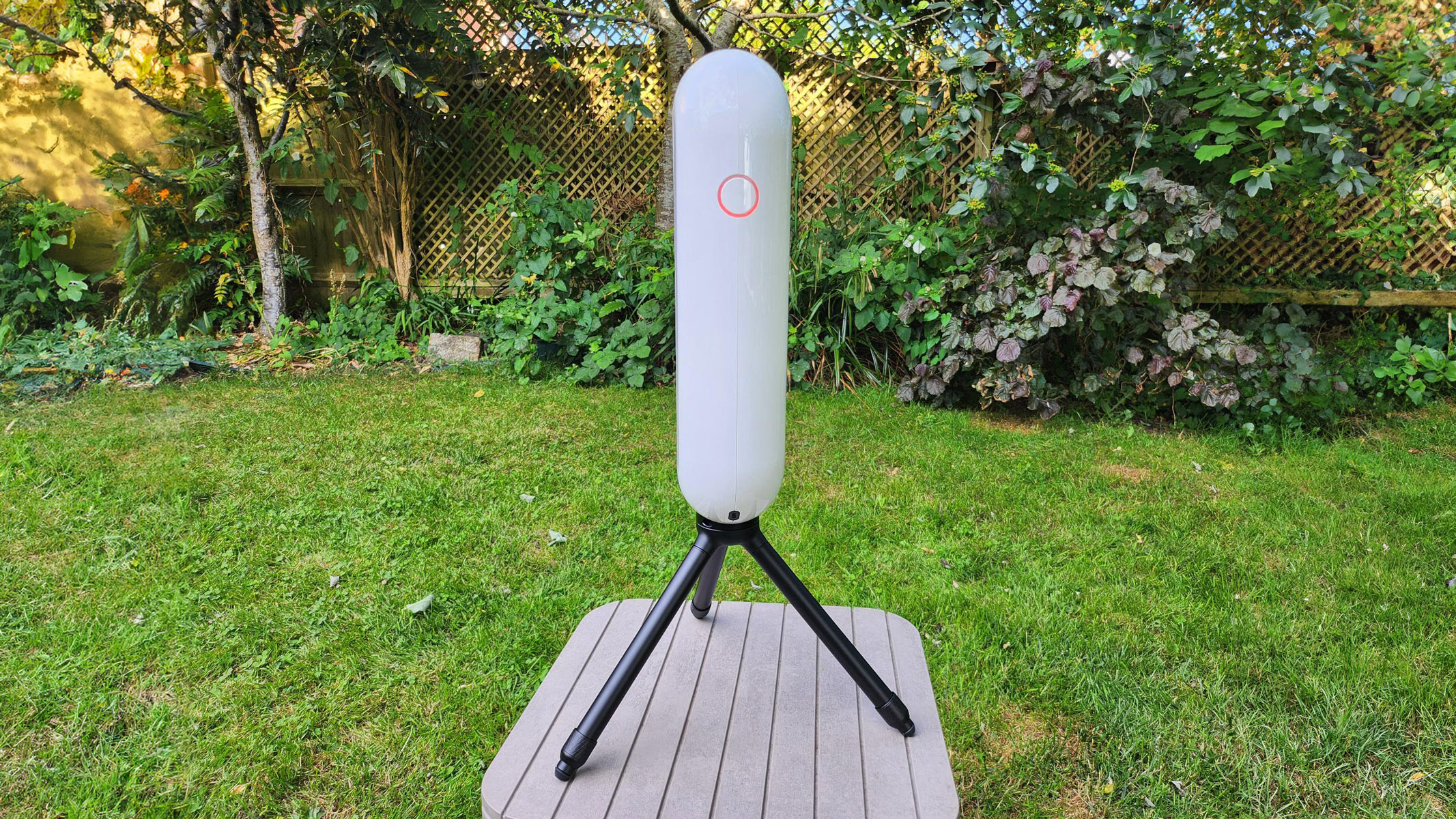 The Vaonis Vespera Pro in neutral position with the power button visible with trees and grass in the background.