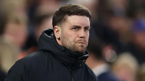 Getty Images Fabian Hurzeler in a black rain coat.