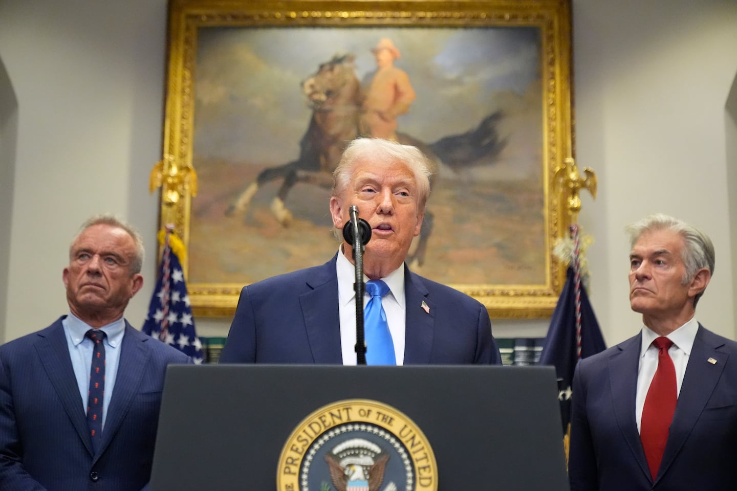 President Trump speaks in the Roosevelt Room of the White House, Monday, Sept. 22, 2025, in Washington, as Health and Human Services Secretary Robert F. Kennedy Jr., left, and Centers for Medicare & Medicaid Services administrator Dr. Mehmet Oz listen.