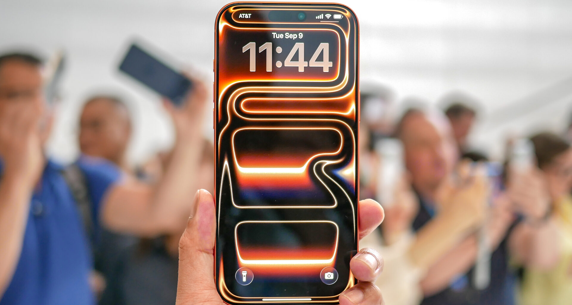 An orange Apple iPhone 17 Pro Max with its default neon wallpaper