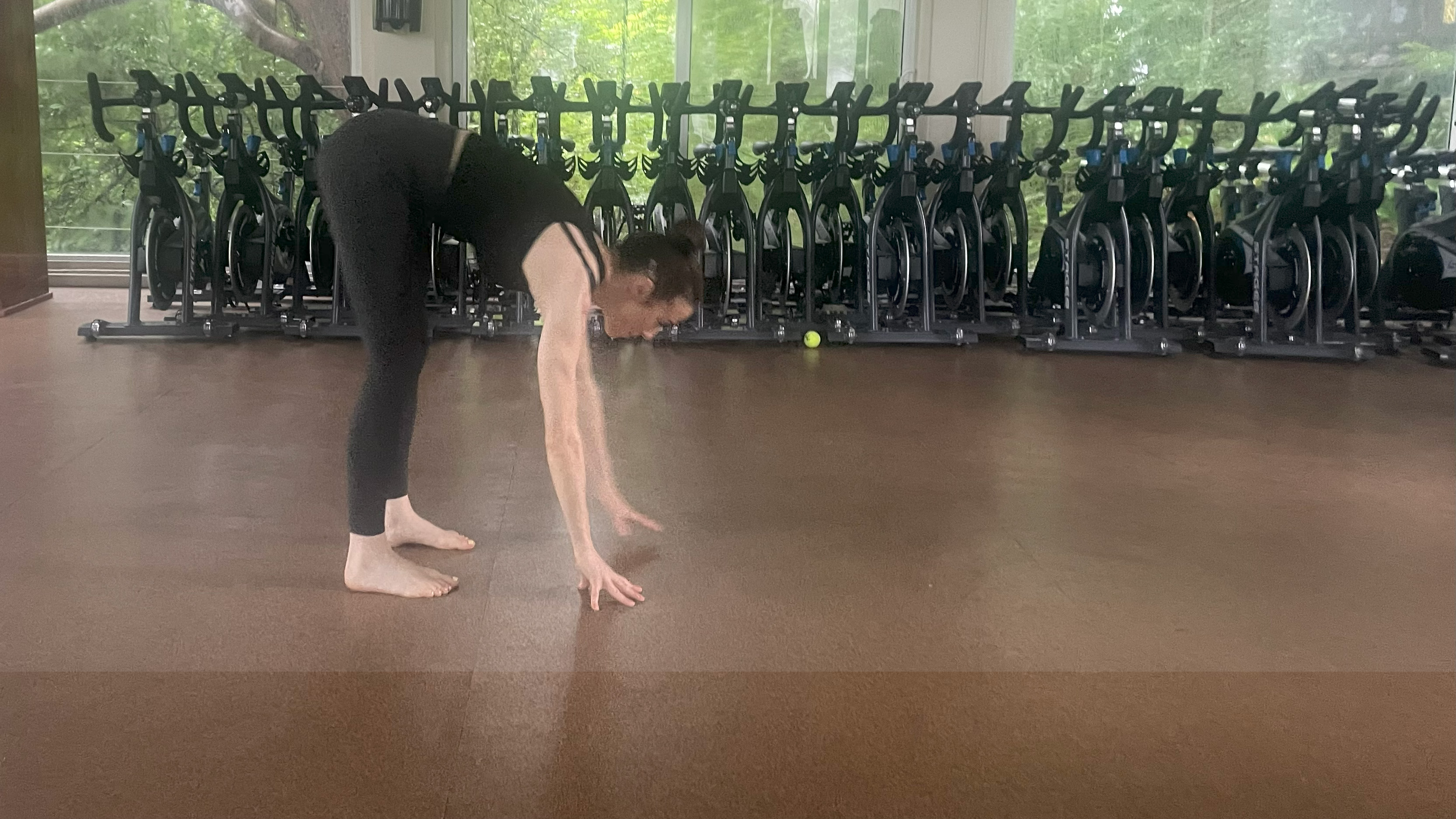 Lucy performing the inchworm exercise in the gym studio