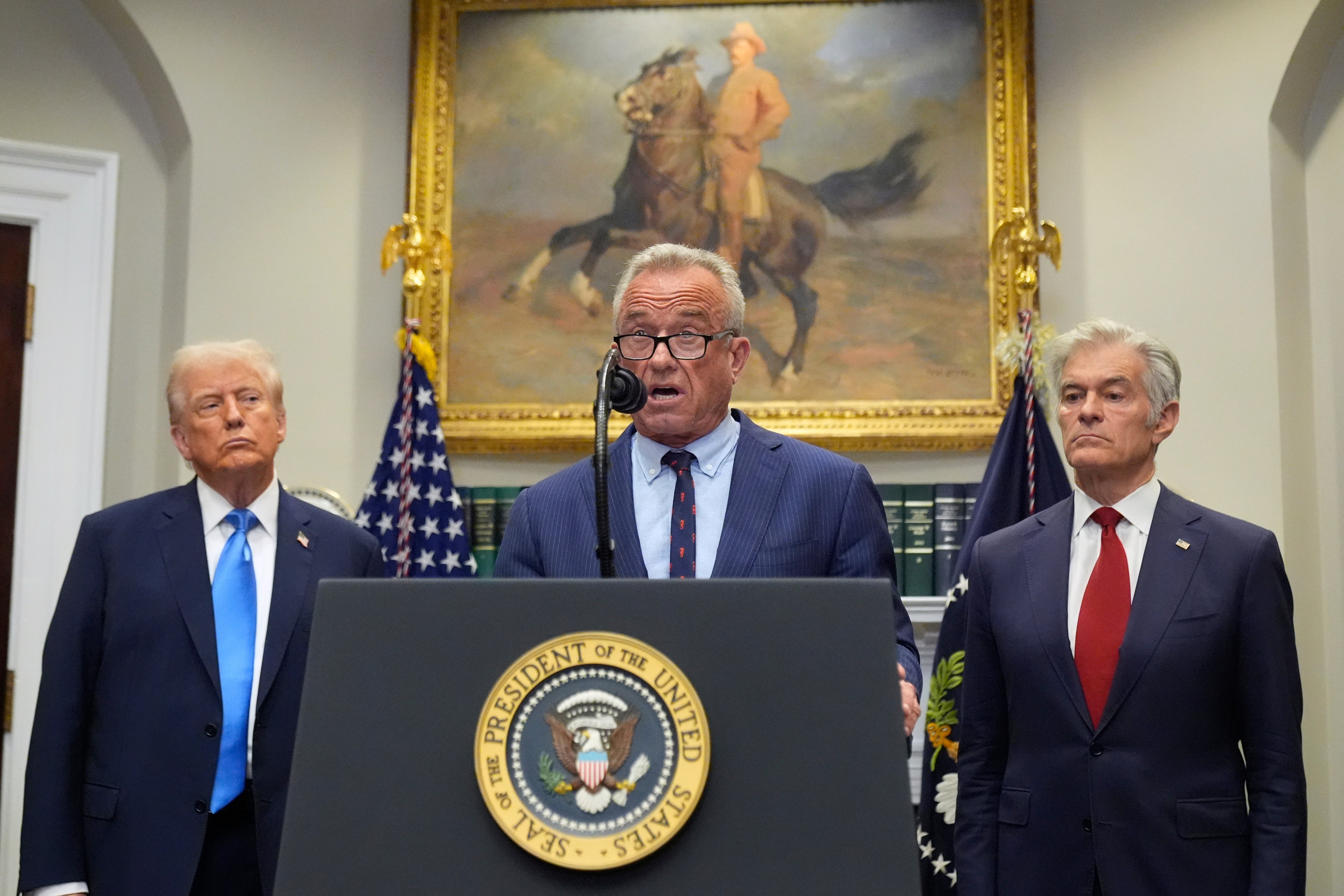 Dr Oz, right, stood alongside Donald Trump and RFK Jr. as Trump gave unqualified medical advice to women from behind the presidential seal on Monday