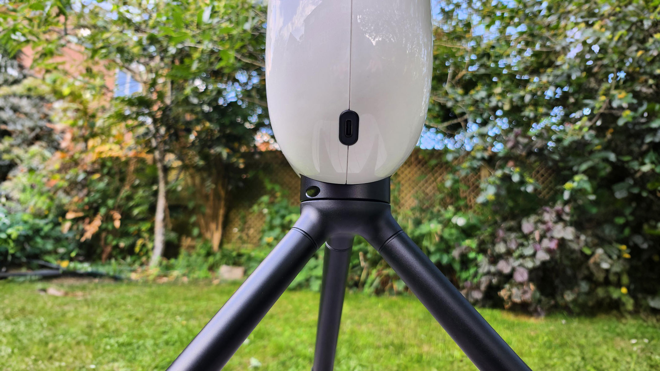 The bottom of Vaonis Vespera Pro showing the USB-C port with trees and grass in the background.