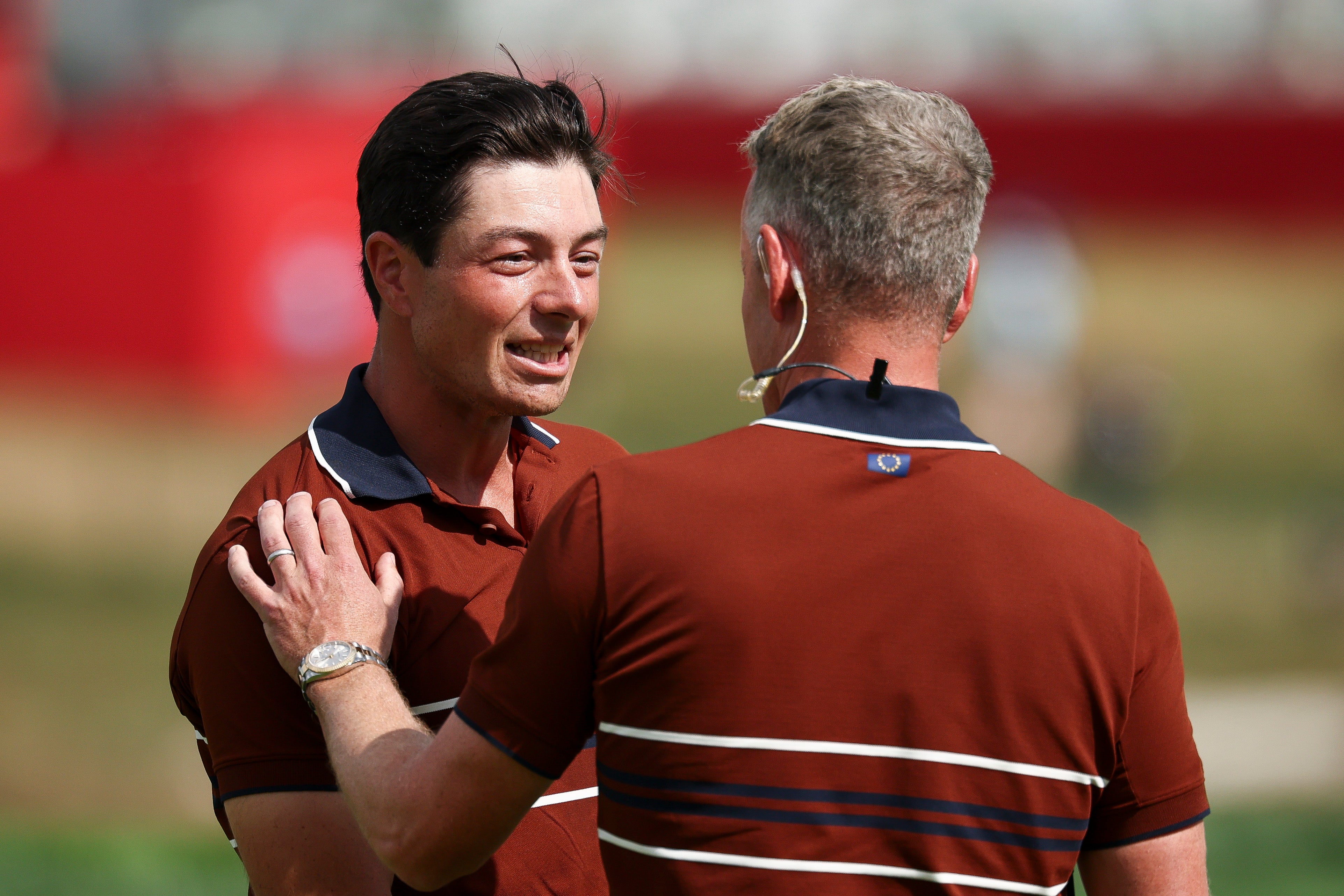 Viktor Hovland of Team Europe talks with captain Luke Donald