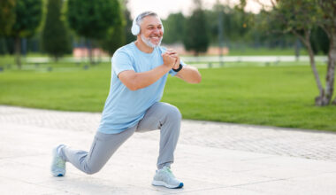 a man in headphones doing a lunge outside