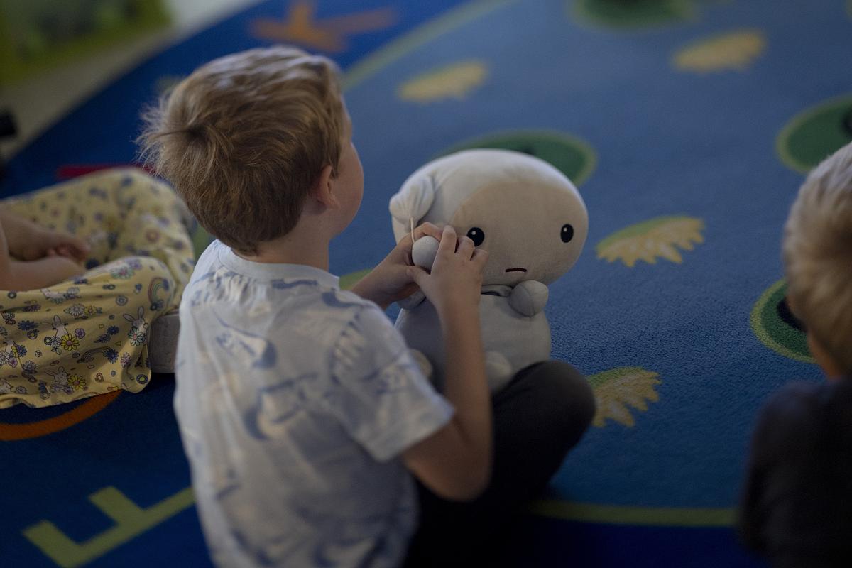 A preschool student holds onto a stuffed animal meant to represent sadness
