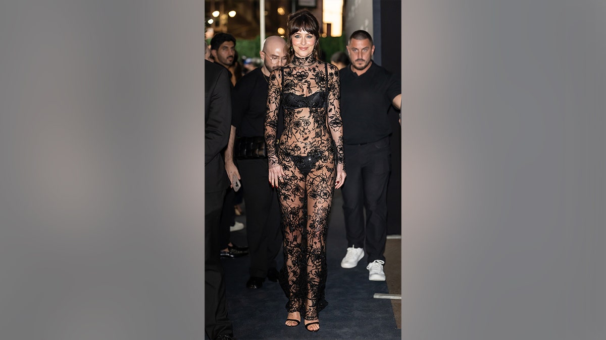 Dakota Johnson in a sheer black dress at the Kering Foundation's Caring for Women dinner in September 2025.