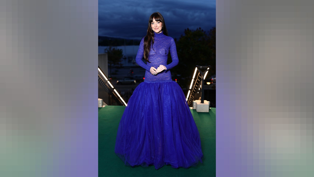 A full body shot of Dakota Johnson in a blue sheer dress at the Zurich Film Festival in September 2025.