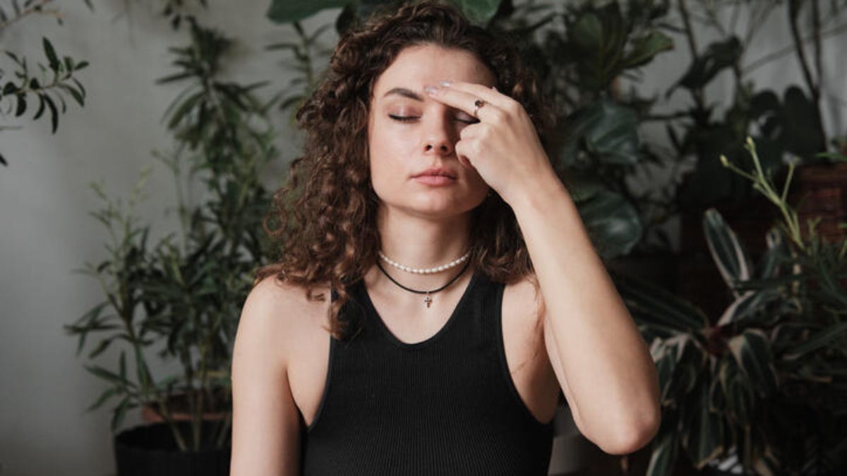 Woman pressing her forehead to ease her anxiety