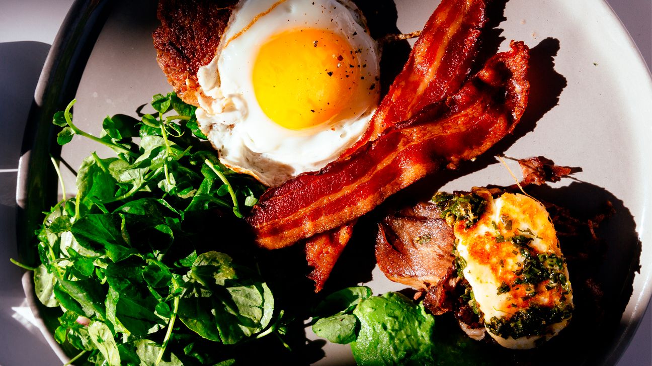 Keto breakfast of eggs, bacon, burger, and greens