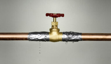 Closeup shot of the leaking water pipe with red valve