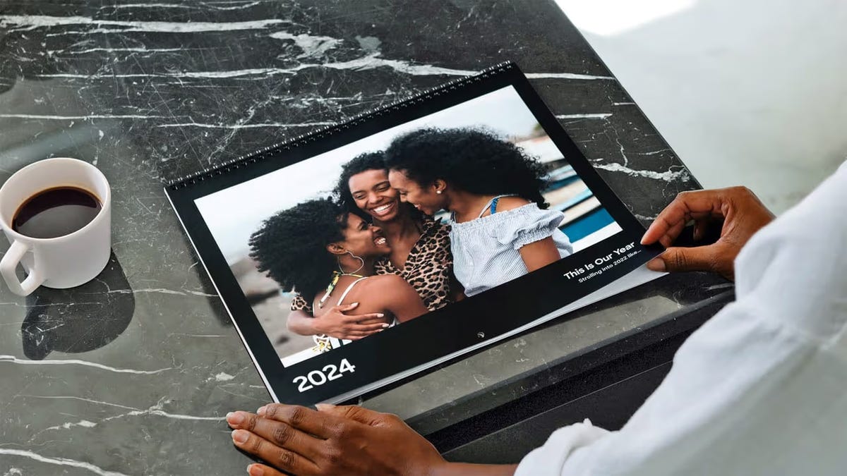 A photo of a calendar showing a family photo on a kitchen countertop