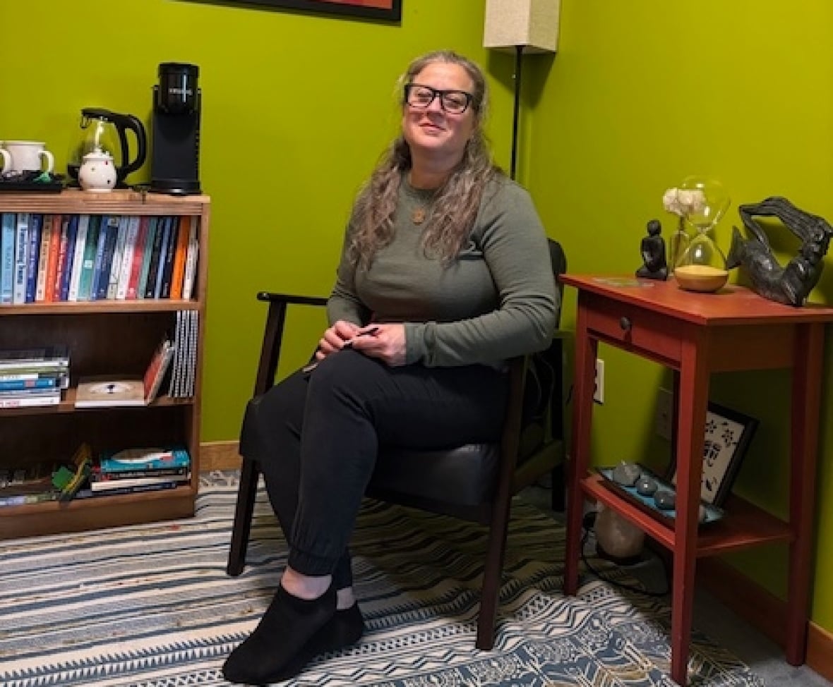 A woman sits in a chair in an office 