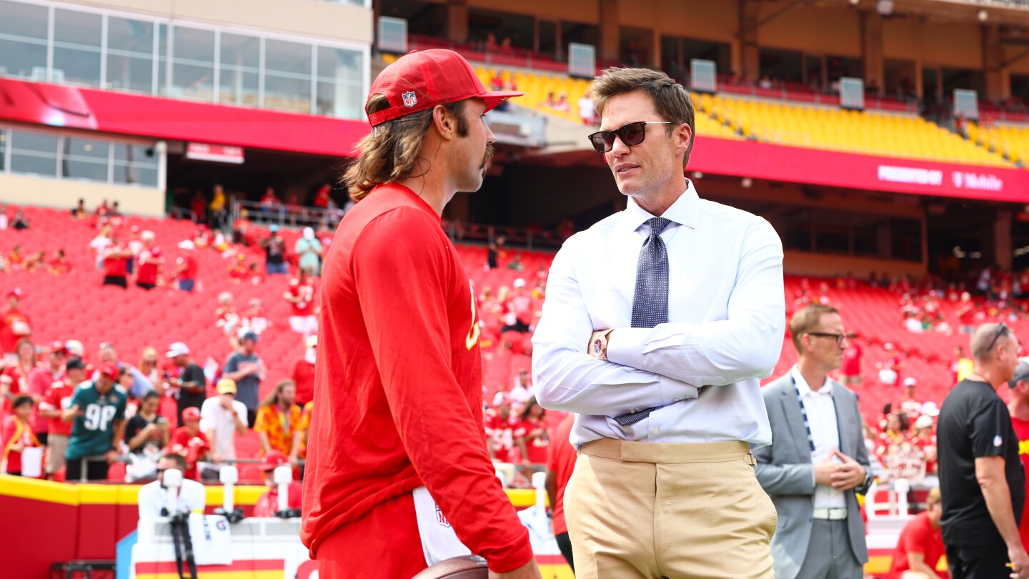 Tom Brady is sitting in the Raiders' coaching box on Monday night
