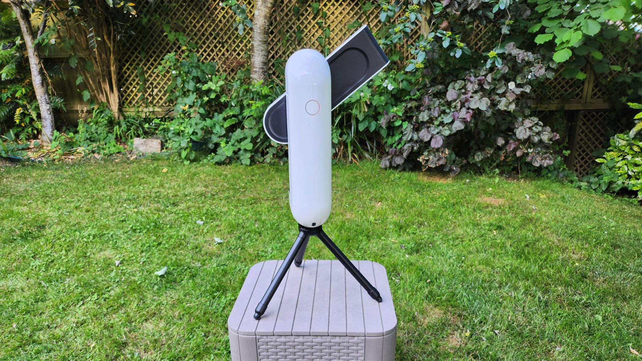 A side on view of the Vaonis Vespera Pro pointing up with grass and plants in the background.