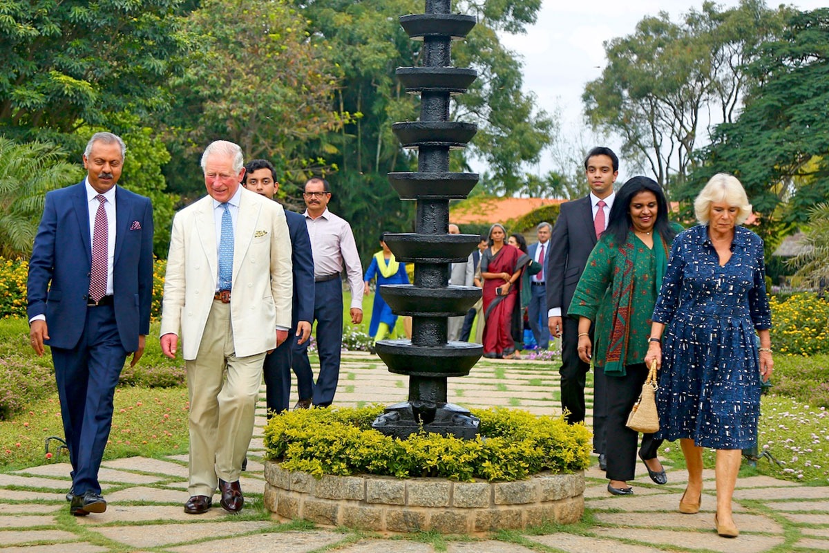 King Charles III and Queen Camilla walking with others at Soukya resort.