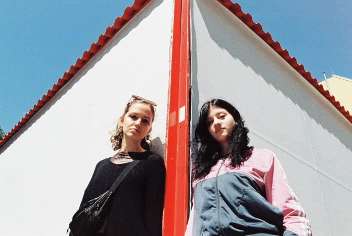 Two women separated by red post (Courtesy Lomography)