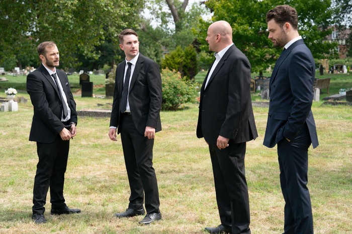 Ben and Callum standing together as Callum looks towards Stuart and Johnny in EastEnders