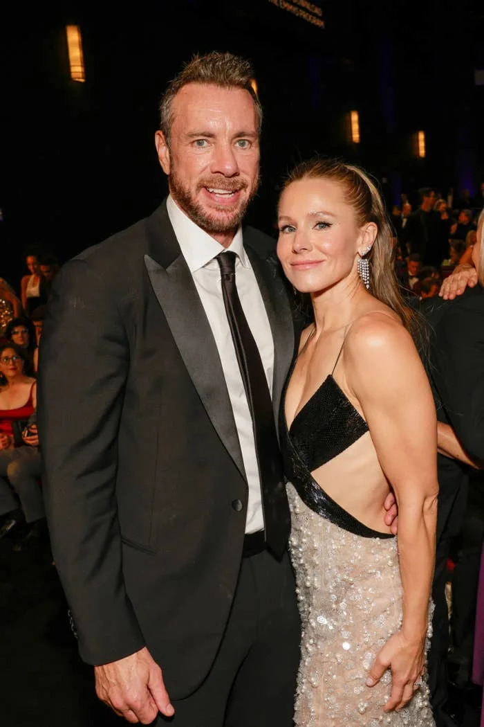 Dax Shepard in a suit and Kristen Bell in a sequined dress pose together at an event