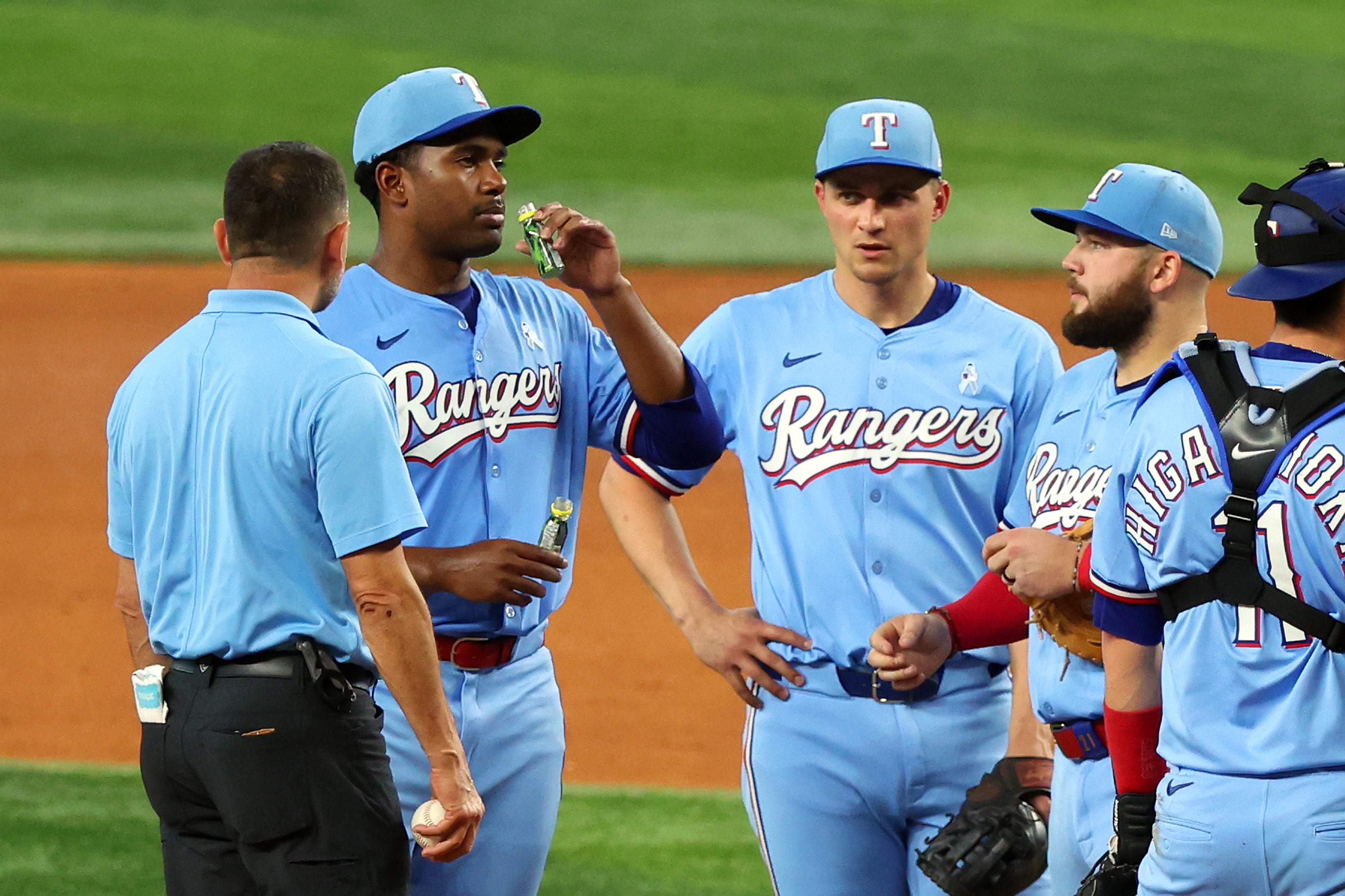 Kumar Rocker of the Texas Rangers drinks a couple of shots of pickle juice at Globe Life Field in Arlington, Texas, last June. Pickle juice is often used by athletes to prevent muscle cramps
