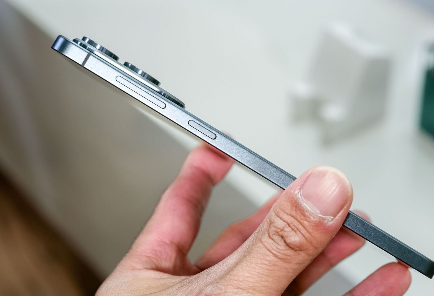 Unbranded smartphone held in hand showing volume buttons.