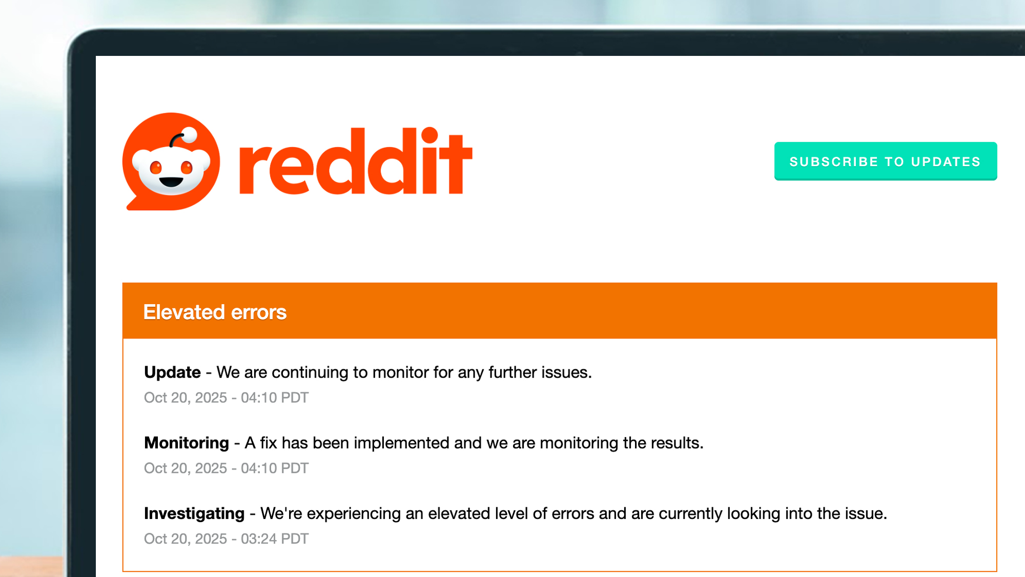 A laptop screen showing issues on the Reddit status page