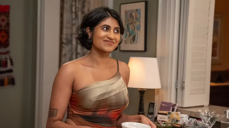 Issa In a one-shoulder dress holding a bowl and smirking on Adults