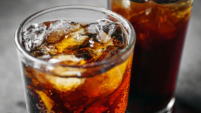 Two glasses filled with cola and ice