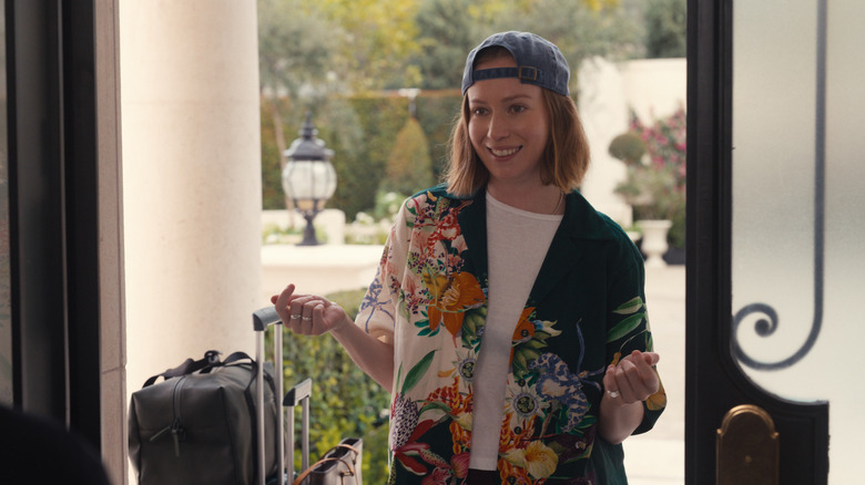 Hannah Einbinder as Ava Daniels with her Hawaiian shirt and luggage at the front door on Hacks