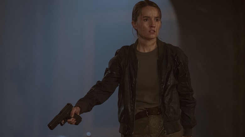 Kaitlyn Dever as Abby holding a gun at someone in The Last of Us