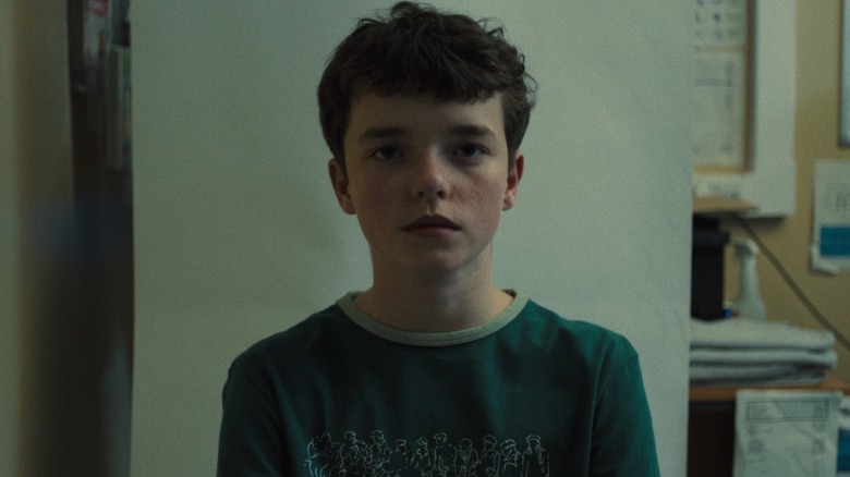 Owen Cooper as Jamie Miller having his mugshot taken in a police station