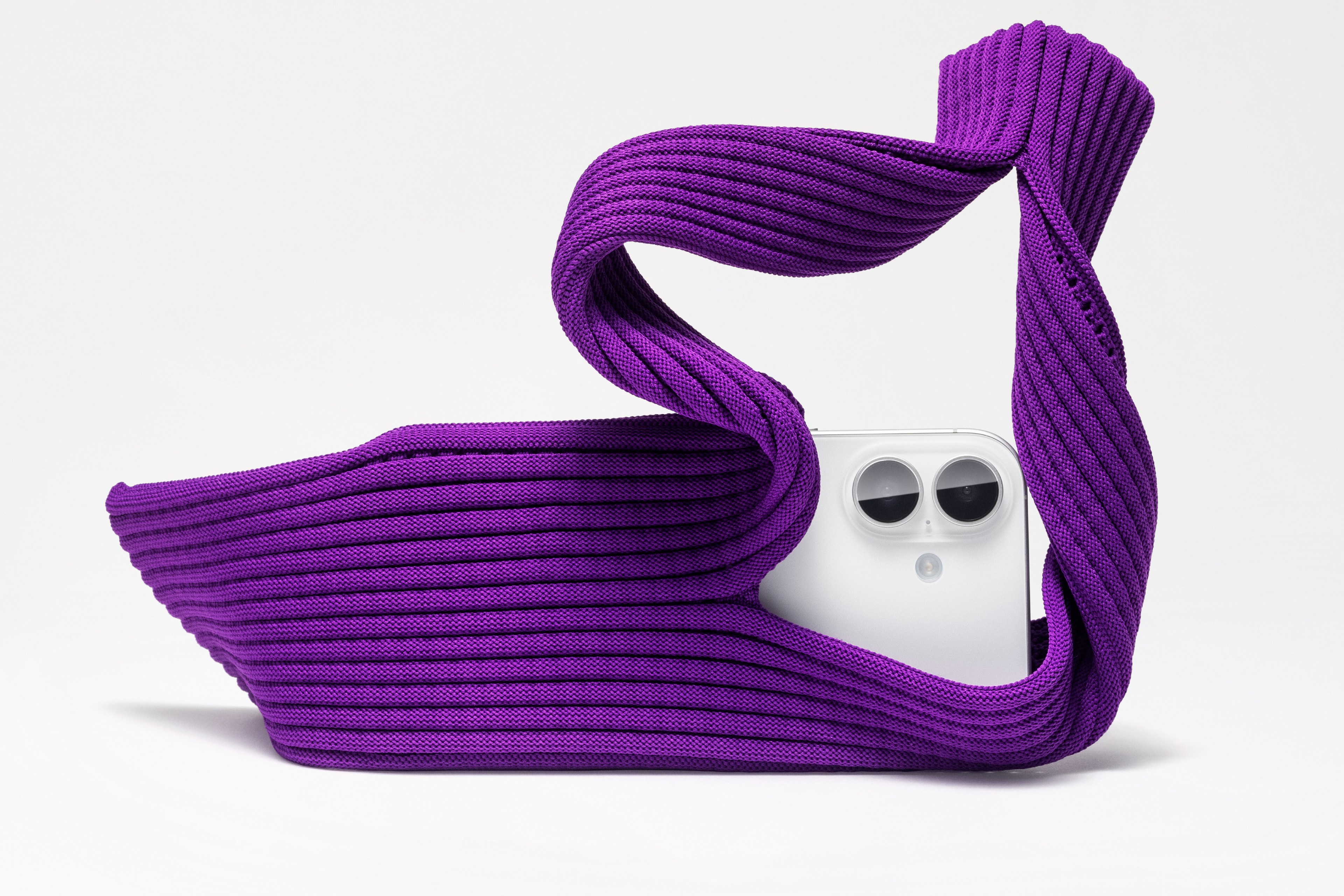 An iPhone Pocket, made of purple 3D-knitted material, holding a white iPhone.