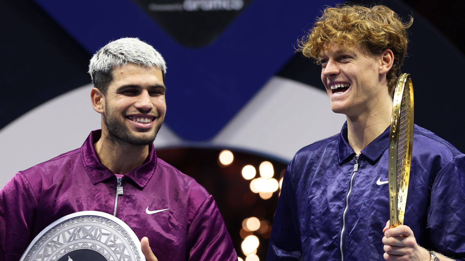 Jannik Sinner of Italy (R) and Carlos Alcaraz of Spain share a joke after receiving their trophies after the Men's Single's Final on day thr
