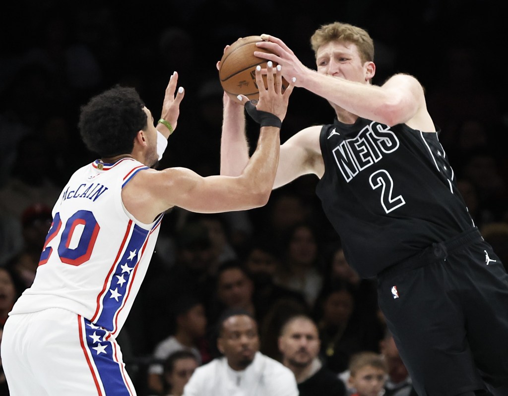Danny Wolf, who had five points and five rebounds, passes the ball around Jared McCain during the Nets' loss to the 76ers. 
