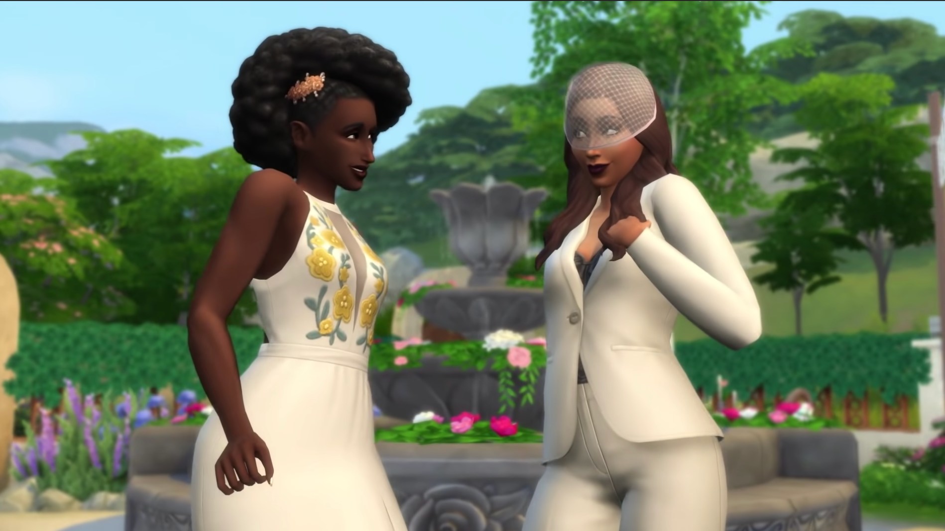 Screenshot from The Sims 4 Wedding Stories pack featuring a dark-skinned woman in a white wedding dress, and a brown woman in a white pantsuit and wedding veil.