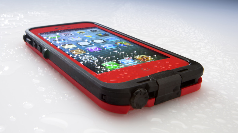 A closeup of a phone in a thick protective case, focusing on the fact that the charging port is covered by the case