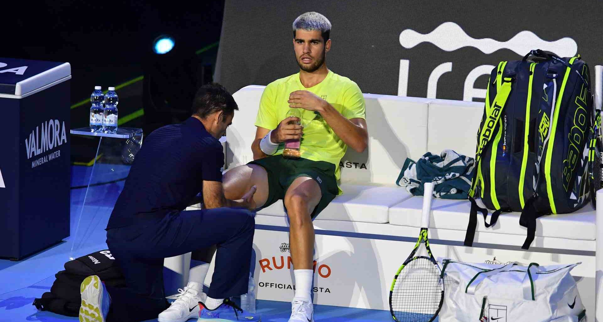 Carlos Alcaraz receives a medical timeout during Sunday's Nitto ATP Finals title match against Jannik Sinner.