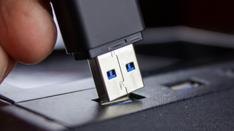 A closeup of a USB-A device being put into a USB port