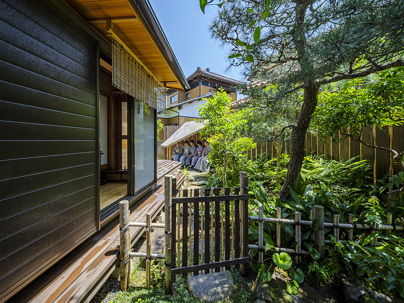 moss-covered earthen roof shields teahouse’s waiting area in japan