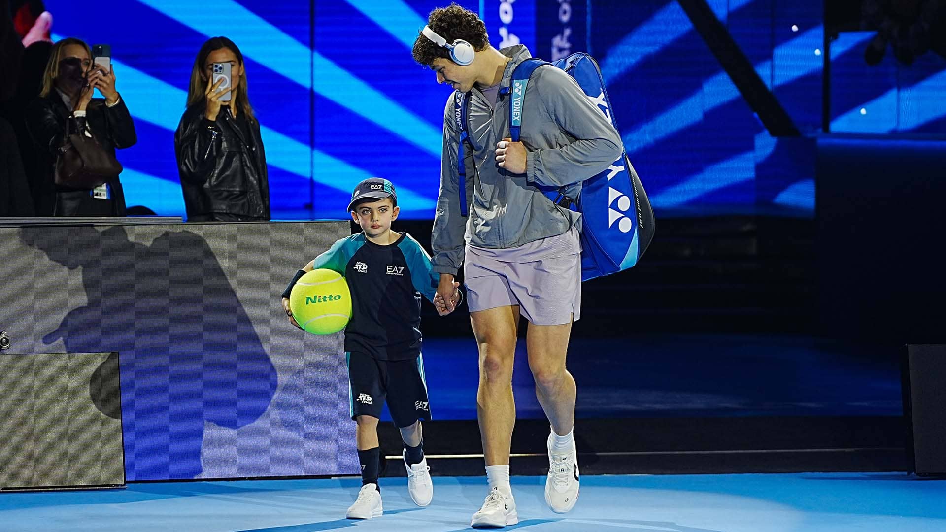 Nitto mascot Gioele walks on court with Ben Shelton on Sunday in Turin.