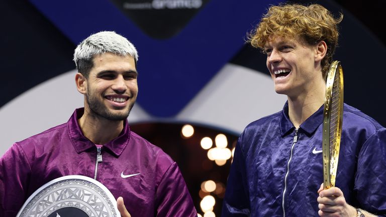 Jannik Sinner of Italy (R) and Carlos Alcaraz of Spain share a joke after receiving their trophies after the Men's Single's Final on day thr