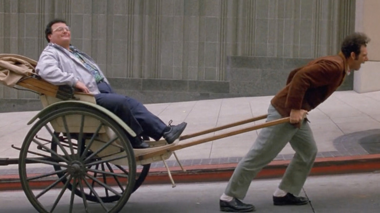 Wayne Knight as Newman riding on a rickshaw pulled by Michael Richards as Kramer in Seinfeld